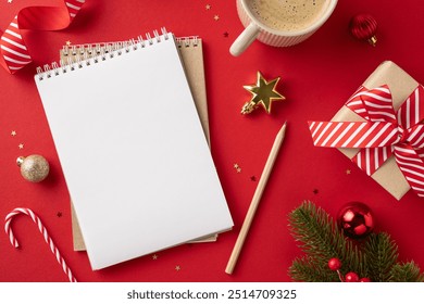 A top-down view of a Christmas-themed desk featuring a blank notebook, coffee, gifts, and ornaments on a red background - Powered by Shutterstock