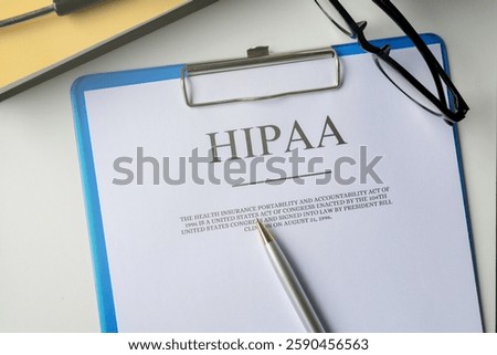 A top-down view of a clipboard with a "HIPAA Document" resting on an office table. This setup represents healthcare regulations, data security, and legal compliance in protecting medical records.