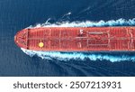 Top-down view of a crude oil tanker speeding through calm waters with trails of foam around her. Powerful diesel engine of the oil tanker roars at full speed and leaves wake water on the Ocean