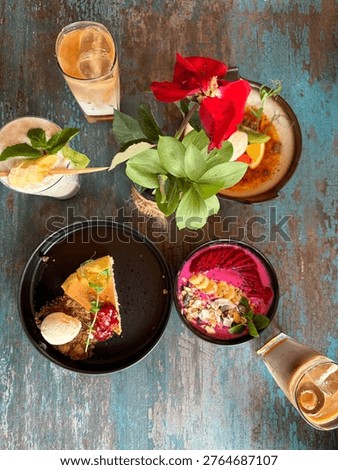 Top-down view of a delicious spread of various dishes, including appetizer, main course, and drink, served on a rustic wooden table