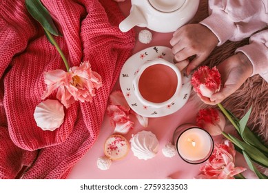 A top-down view of a delightful spread featuring a warm beverage, delicate flowers, and sweet treats, creating a serene atmosphere