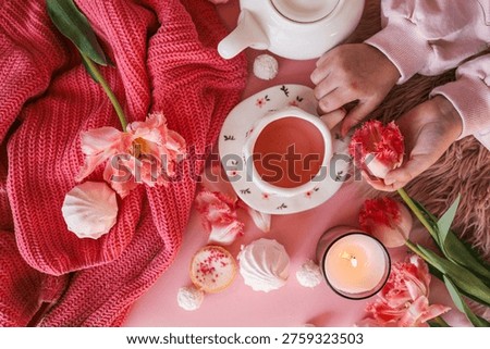 A top-down view of a delightful spread featuring a warm beverage, delicate flowers, and sweet treats, creating a serene atmosphere