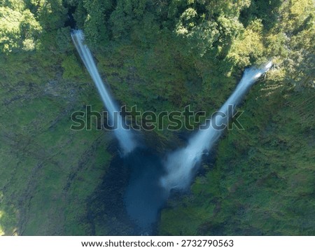 Top-down view emphasizing the symmetry of Tad Fane’s twin cascades converging toward a dark plunge pool.