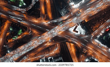 Top-down view of fast-moving cars on a highway, intense traffic during rush hour at a city crossroad, modern multi-level intersection with beautifully moving vehicles. - Powered by Shutterstock