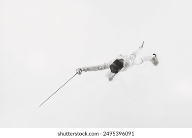 Top-down view of fencer in action, lunging with his epee performing his power and strength during battle against white studio background. Concept of professional sport, competition, achievement. Ad - Powered by Shutterstock