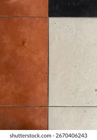 Top-down view of a geometric floor pattern with terracotta, white, and black tiles. Minimalist and abstract texture background for interior design or architectural concepts.
