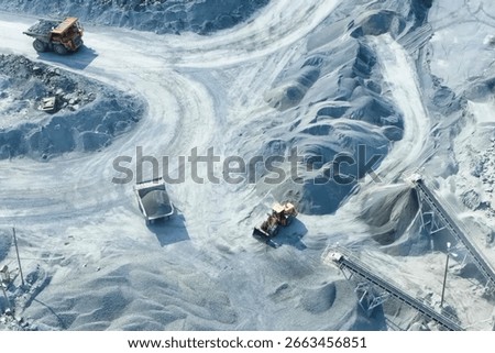 A top-down view of mining trucks driving along the road inside