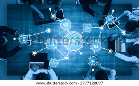 A top-down view of a modern workspace showcasing professionals engaging with technology. Digital elements highlight connectivity and collaboration in a team setting. Tessel