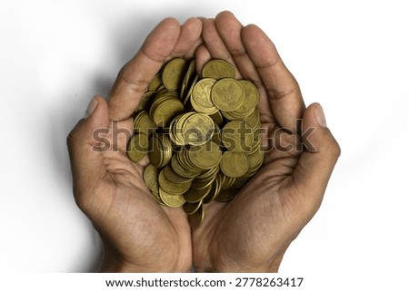 A top-down view of a pair of hands cupping a large pile of Indonesian gold-colored coins. The image symbolizes savings, charity, financial success, and wealth management. The hands are positioned in the center, isolated against a clean white background, highlighting a concept of prosperity.