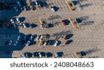 Top-down view of a parking lot with neatly aligned cars casting long shadows in the early morning light.