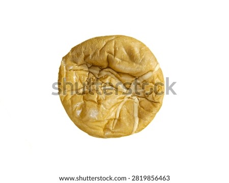 Top-down view of a round, wrinkled bun on an isolated white background. (Pandangan dari atas dari roti bundar yang keriput di latar belakang putih terisolasi.)