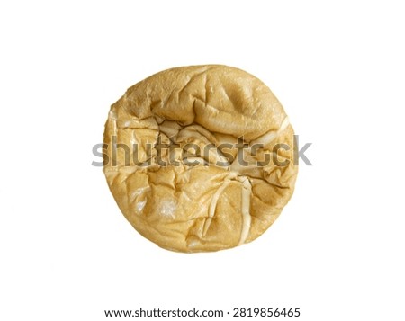 Top-down view of a round, wrinkled bun on an isolated white background. (Pandangan dari atas dari roti bundar yang keriput di latar belakang putih terisolasi.)