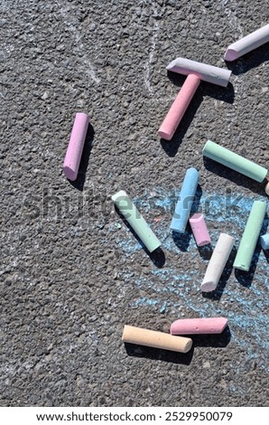 Top-down view of a section of asphalt with colored chalks