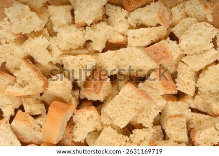 A top-down view shows a pile of irregular, bite-sized pieces of stale bread, perfect for making croutons or stuffing