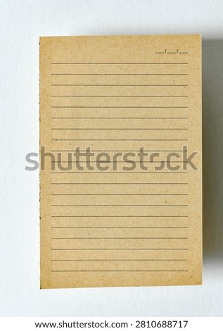 A top-down view of a single, vertically oriented, blank notecard made of textured, light brown kraft paper, positioned.