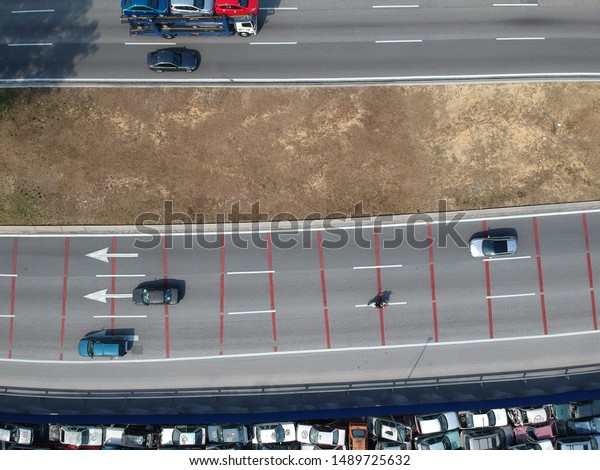 Topdown view of three lane highway and vehicle\
transport. 