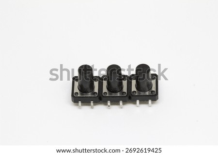 Top-down view of three long-stem tactile pushbutton switches aligned side-by-side, isolated on white