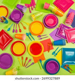 Top-down view of two vibrant setups featuring square and round plates, bowls, cups, napkins, and cutlery in fuchsia, purple, red, orange, yellow, blue, and green. Ideal for kids’ parties