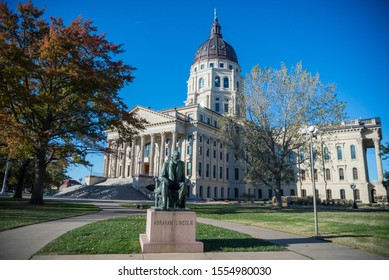 Topeka, Kansas / United States of America - November 2nd 2019 : Kansas State Capitol building in Topeka.  Statue of Abraham Lincoln in foreground.  Blue sky during the afternoon.