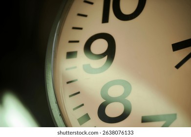 Top-left angle view of an analog clock captured from 9 to 11 o’clock positions, with natural light reflection.
