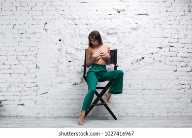 Topless Brunette Woman Sitting On A Directors Chair
