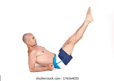 Topless Man Lying Down On The Ground Doing Lower Abs Exercise By Lifting His Legs Up. Young Guy Working Out On The Floor. Isolated On White Background.