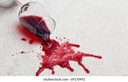 A toppled glass of red wine with a dirty carpet. - Shutterstock ID 69170992
