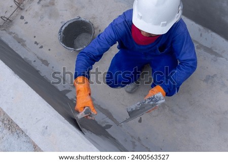 Topview of Construction worker use steel trowel for plastering concrete wall surface 