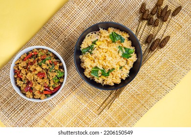 Top-view of Fried Rice in black bowl and Stir-fried basil with minced pork hot and spicy taste serving together,Thai famous food, Hot and spicy food concept, Combo set for eatting.   - Shutterstock ID 2206150549