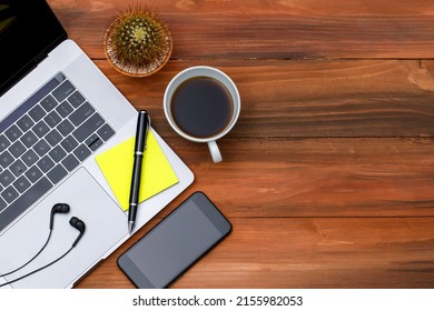 Topview Or Top Down Shot Of Laptop Notebook Computer With With Black Coffee In White Cup On Wood Background With Copy Space. Business Idea And Creative Working Concept.