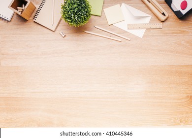 Topview Of Wooden Desk With Office Tools And Plant. Mock Up