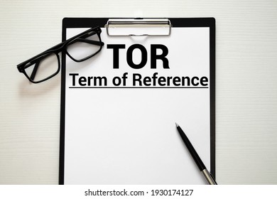 TOR. Terms Of Reference acronym on book. Office desk background