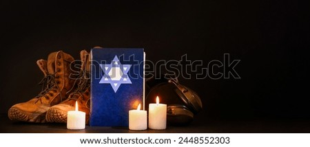 Torah with burning candles and military ammunition on dark background with space for text