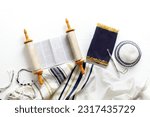 Torah scroll with a pointer, prayer shawl tallit and kippah on a light background