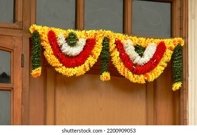 A toran, garland of colorful flowers hung on the main entrance of a middle class home in Delhi as a sign of good omen as well as decoration. - Shutterstock ID 2200909053