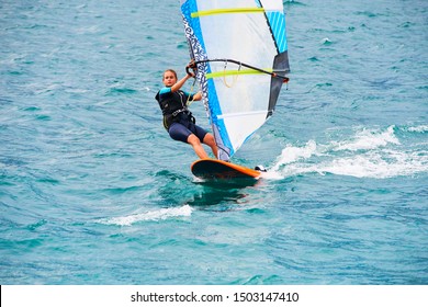 Torbole - Nago, Lago di Garda (Lago Benaco), Italy - July 18, 2019: A windsurfing on Lake Garda in Torbole resort. Windsurfer Surfing The Wind On Waves, Recreational Water Sports, Selective focus