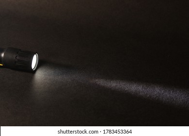 A Torch With Light Beam On A Grainy Black Background