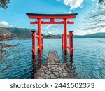 Torii of Hakone Shrine at Lake Ashi in the Hakone area of Kanagawa Prefecture in Honshū, Japan. Traditional red Japanese gate in the crater lake.