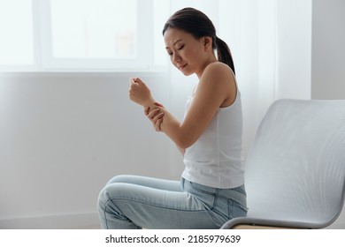 Tormented Suffering From Dislocation Tanned Beautiful Young Asian Woman Hurting Holding Painful Wrist At Home Interior Living Room. Injuries Poor Health Illness Concept. Cool Offer Banner