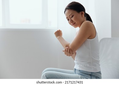 Tormented Suffering Tanned Beautiful Young Asian Woman Hurting Holding Painful Elbow At Home Interior Living Room. Injuries Poor Health Illness Concept. Cool Offer Banner