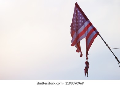Torn American flag on the sky background