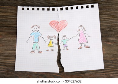 Torn Apart Drawing Of A Family On Wooden Background