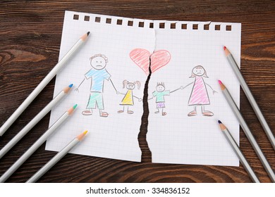 Torn Apart Drawing Of A Family On Wooden Background