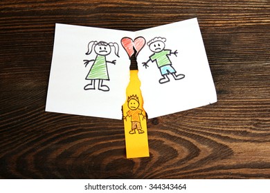 Torn Apart Drawing Of A Family On Wooden Background