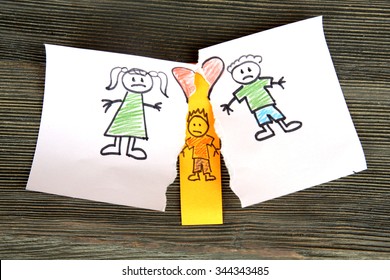 Torn Apart Drawing Of A Family On Wooden Background