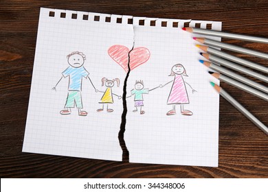 Torn Apart Drawing Of A Family On Wooden Background