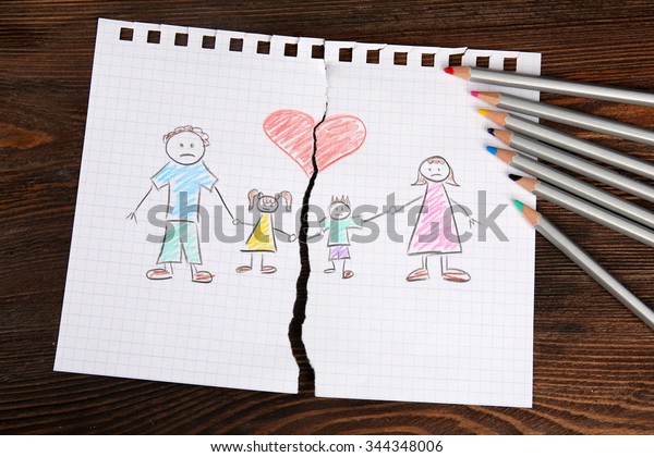 Torn apart\
drawing of a family on wooden\
background