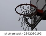 Torn basketball rim in a moody atmosphere from a side view