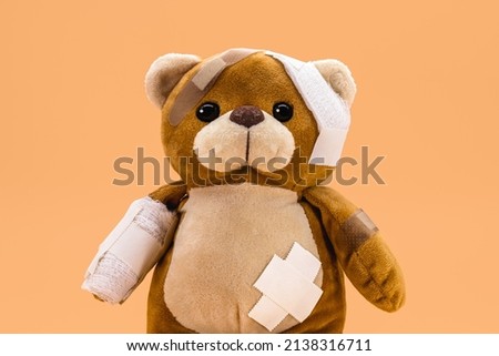 torn children's toy with bandages and bandages, concept of childhood violence or child aggression