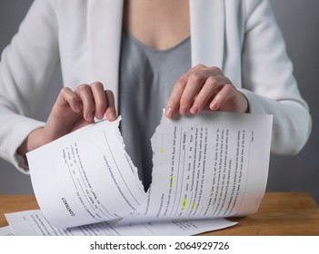 Torn contract in hands. Terminated agreement concept. Ripping paper document and breaching rules. - Shutterstock ID 2064929726